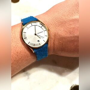 Skagen brand watch - matte silver dial & blue felt band with gold detail.